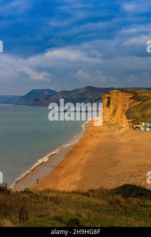 Un puits de lumière solaire d'automne illumine la falaise est de grès instable et dangereuse sur la côte jurassique à Burton Bradstock, Dorset, Angleterre, Royaume-Uni Banque D'Images