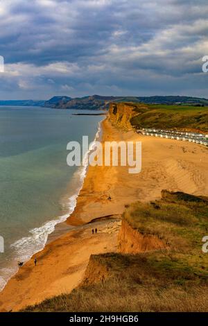 Un puits de lumière solaire d'automne illumine la falaise est de grès instable et dangereuse sur la côte jurassique à Burton Bradstock, Dorset, Angleterre, Royaume-Uni Banque D'Images