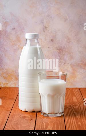 Bouteille et verre de lait sur une table en bois marron.Fond de nourriture, ingrédient de cuisson, boisson.Une alimentation saine, une source de calcium Banque D'Images