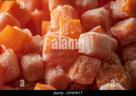 Des morceaux de cube de carottes fraîches surgelées ferment l'arrière-plan Banque D'Images