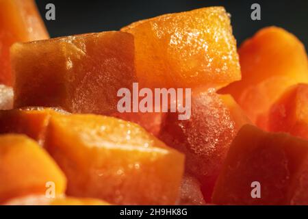 Des morceaux de cube de carottes fraîches surgelées ferment l'arrière-plan Banque D'Images