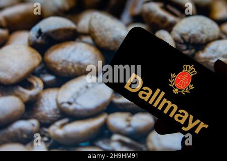 Rheinbach, Allemagne 1 octobre 2021, le logo de la marque 'Dallmayr' sur l'écran d'un smartphone devant une photo avec des grains de café rôtis Banque D'Images