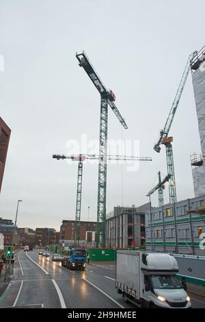 Dublin, Irlande - 12.03.2021: Construction sans fin à dublin, nouvelles constructions, construction de bureaux avec beaucoup de grues à l'arrière sous les nuages Banque D'Images