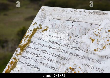 Un panneau sur la faille de San Andreas qui s'écaille et est couvert de lichen, à Bodega Head en Californie. Banque D'Images