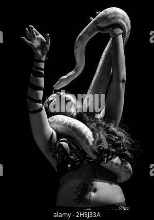 Un charmeur de serpents et une danseuse se produisent sur scène dans le cadre de la troupe de danse arabe du quartier arabe lors de leur spectacle trimestriel au Islington Assembly Hall de Londres Banque D'Images