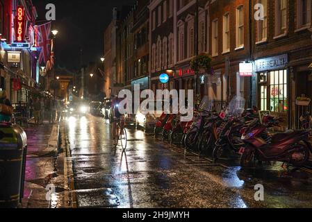 Une vue sur une rangée de cyclomoteurs et un cycliste sur Dean Street à Soho à Londres lors d'une nuit de pluie.D'une série de photos prises lors d'une nuit de pluie à Soho, Londres.Date de la photo : jeudi 27 juillet 2017.Le crédit photo devrait se lire: Richard Gray/EMPICS Entertainment Banque D'Images