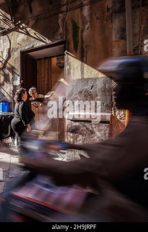 Un homme en mobylette passe devant trois habitants de la région pour discuter dans les rues arrière de Palerme.D'une série de photos de voyage en Sicile, Italie.Date de la photo : lundi 9 octobre 2017.Le crédit photo devrait se lire: Richard Gray/EMPICS Entertainment Banque D'Images