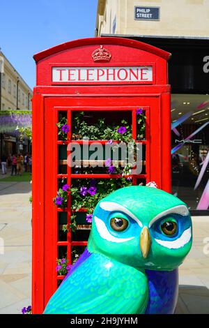 Une boîte téléphonique rouge traditionnelle a été réinstallée pour abriter des plantes à côté d'un modèle de hibou vert, l'une des 80 hiboux formant un sentier de sculpture d'art public appelé Minerva's Owls of Bath 2018 à Bath, au Royaume-Uni.Date de la photo : jeudi 5 juillet 2018.Le crédit photo devrait se lire: Richard Gray/EMPICS Banque D'Images