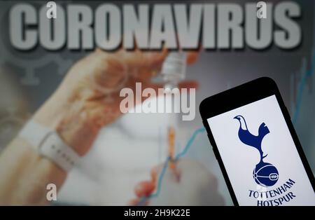 Photo du dossier datée du 09-01-2021 du logo Tottenham Hotspur football Club affiché sur un téléphone portable avec une illustration du coronavirus sur un moniteur en arrière-plan.Les plans de Tottenham pour gérer une période de jeux occupée ont été entravés par une épidémie de coronavirus au club.Date de publication : le mardi 7 décembre 2021. Banque D'Images