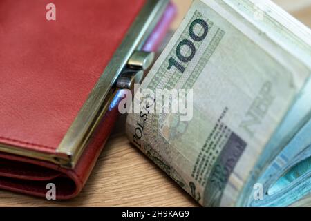 Paquet épais de billets pliés de 100 zlotys de Pologne, table, portefeuille, gros plan Banque D'Images