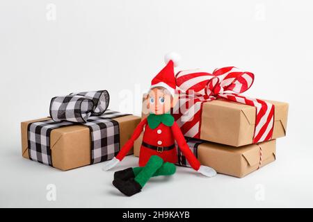 Jouet Elf de Noël avec boîtes-cadeaux sur fond blanc avec espace de copie.L'esprit de Noël, la tradition familiale de Noël. Banque D'Images