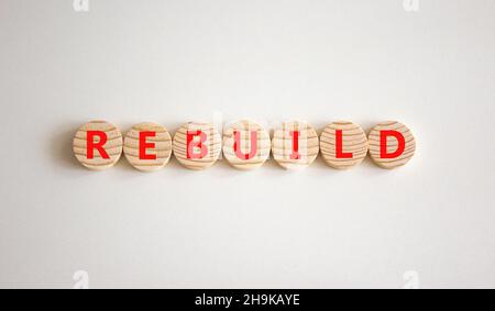 Reconstruire et construire le symbole.Le mot concept reconstruire sur des cercles en bois.Magnifique arrière-plan blanc, espace de copie.Concept de reconstruction et de construction d'entreprise. Banque D'Images