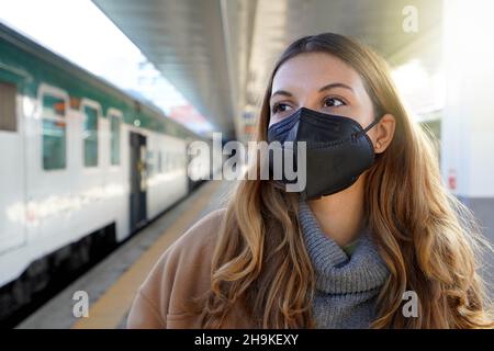 Portrait d'une jeune femme portant un masque de protection noir KN95 FFP2 à la gare Banque D'Images