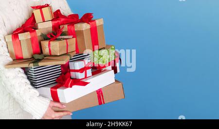 sur fond bleu long l'homme tient beaucoup de cadeaux différents dans ses mains, l'espace Banque D'Images