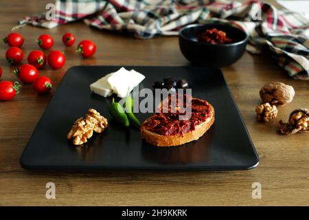 Un petit-déjeuner turc classique servi avec de la pâte de tomates et du pain, des noix, du fromage, des olives, des tomates et des poivrons. Banque D'Images