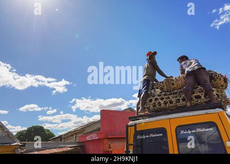 Ilakaka, Madagascar - 05 mai 2019: Deux Malgaches inconnus debout sur le toit de la voiture, organisant des poulets dans des cages en paille pour le transport , voir belo Banque D'Images