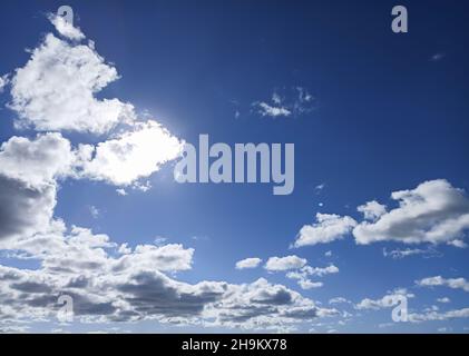 Soleil caché par un nuage dans un ciel avec des nuages et des clairières Banque D'Images