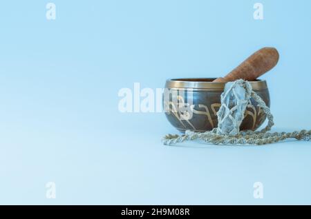 Bol de chant tibétain isolé avec collier macrame fait main avec cristal de quartz clair sur fond blanc avec espace de copie Banque D'Images