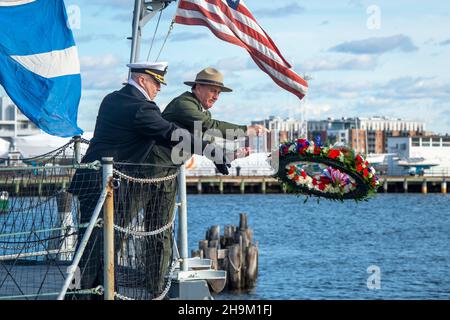 Boston, États-Unis.07ème décembre 2021.Cmdr. Marine américaineJohn Benda, commandant de l'USS Constitution, et Michael Creasey, directeur général du National Park Service Boston, lancent une couronne dans le port lors de la commémoration du 80e anniversaire de l'attaque de Pearl Harbor le 7 décembre 2021 à Boston, Massachusetts.Crédit : MC2 Skyler Okerman/US Navy/Alay Live News Banque D'Images