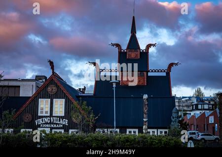 Hafnarfjordur, Islande - 17 juillet 2021 : un hôtel viking dans la ville de Hafnarfjordur.Architecture traditionnelle en bois de style viking.Coucher de soleil, nuages roses. Banque D'Images