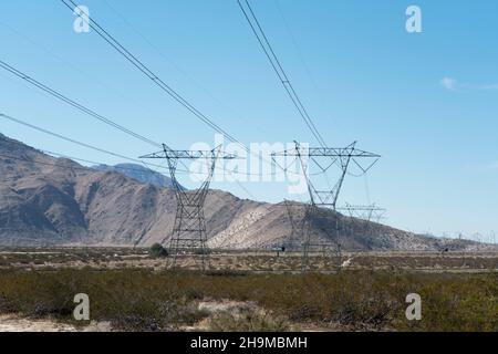 Tours et lignes électriques haute tension s'étendant sur le désert. Banque D'Images