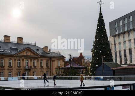 Les gens visitent le marché de Noël à Cracovie, le patinage sur glace familial, la mère avec des enfants, les vacances d'hiver à Cracovie, Pologne Banque D'Images