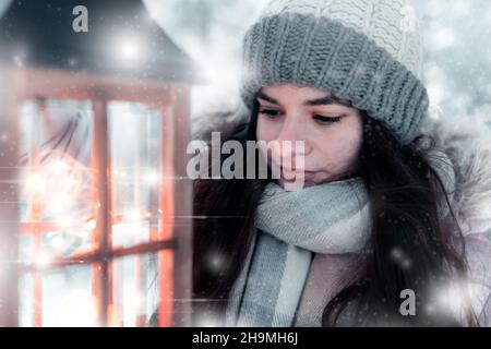 La fille tient une lanterne avec une lumière dans sa main et brille sur son chemin dans la forêt gelée, Noël et l'atmosphère gelée, Bethléem lumière brille moi Banque D'Images