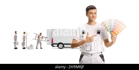 Décorateurs de maison avec une fourgonnette et un jeune homme travailleur pointant sur une nuance de couleur isolée sur fond blanc Banque D'Images