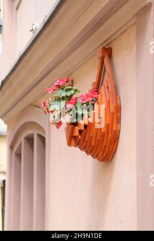 Parterre à fleurs en bois accrochée au mur et en elle fleurs rouges Banque D'Images