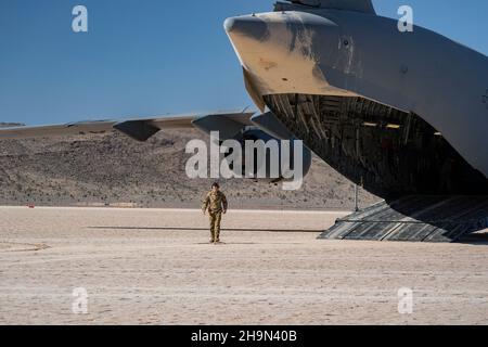 Le chargé de charge de la Force aérienne des États-Unis du 6e Escadron de transport aérien (AS), base interarmées McGuire-dix-Lakehurst (N.J.), attend de charger le M142 High Mobility Artillery Rocket Systems (HImars) affecté au 3e Bataillon, 32e Régiment d'artillerie de campagne, fort Bragg, Caroline du Nord, pendant l'intégration de l'école de la Force aérienne des États-Unis tenue à la base d'armes de Nellis,Nevada, le 4 décembre 2021.La 6e, MISE en place à Nellis pour charger les HImars dans le cadre de l’exercice d’entrée forcée conjointe 21B.(É.-U.Photo de la Force aérienne par Airman 1er classe Zachary Rufus) Banque D'Images