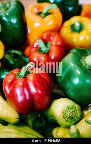 Poivrons jaunes, verts et rouges en démonstration de légumes frais, en vente sur un marché agricole ou agricole. Banque D'Images