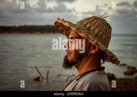 Jeune homme d'âge en chapeau sur le bord du lac.Concept de vie détendue en vacances. Banque D'Images