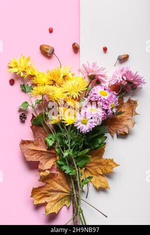 Composition avec de belles fleurs de chrysanthème et des feuilles d'automne sur fond de couleur Banque D'Images