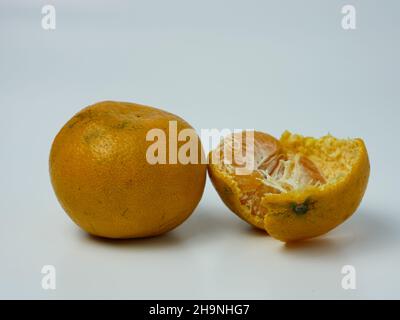 deux oranges, dont une pelée sur fond blanc. concept de fruits sains Banque D'Images