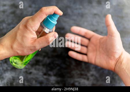 Un homme saupoudrer un antiseptique sur ses mains.Protection contre les virus.L'utilisation de la chlorhexidine pour protéger contre les virus et les bactéries Banque D'Images