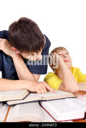 Frère aîné et enfant d'Annoyed sur le bureau d'école sur fond blanc Banque D'Images