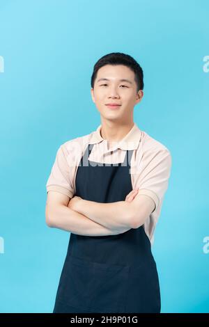 Jeune homme portant un tablier sur fond de couleur Banque D'Images