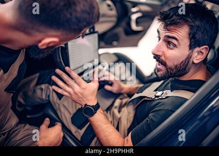 Deux diagnostics mécaniques modernes dans la voiture.Concept de travail. Banque D'Images