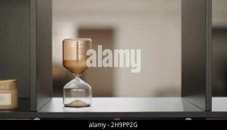 Le sable coule à travers le sablier Banque D'Images