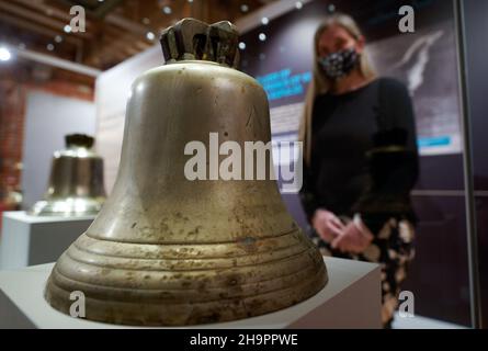 Victoria Ingles, conservateur principal au Musée national de la Marine royale, regarde la cloche du navire du HMS Repulse qui a été coulé avec le HMS Prince de Galles après une attaque aérienne japonaise le 10 1941 décembre.842 hommes ont perdu la vie dans ce qui est l'une des pires catastrophes de l'histoire navale britannique.Date de la photo: Mercredi 8 décembre 2021. Banque D'Images