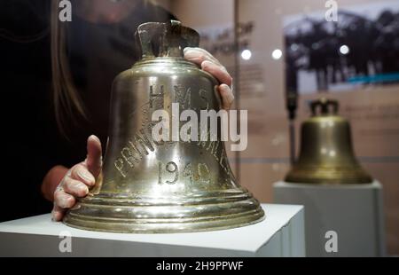 Victoria Ingles, conservateur principal au Musée national de la Marine royale, ajuste la cloche du navire du HMS Prince de Galles qui a été coulé avec le HMS Repulse après une attaque aérienne japonaise le 10 1941 décembre.842 hommes ont perdu la vie dans ce qui est l'une des pires catastrophes de l'histoire navale britannique.Date de la photo: Mercredi 8 décembre 2021. Banque D'Images