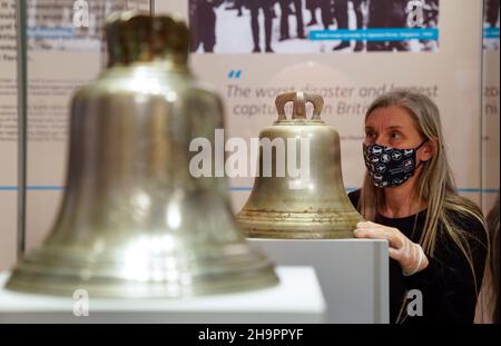 Victoria Ingles, conservateur principal au Musée national de la Marine royale, regarde la cloche du navire du HMS Repulse qui a été coulé avec le HMS Prince de Galles après une attaque aérienne japonaise le 10 1941 décembre.842 hommes ont perdu la vie dans ce qui est l'une des pires catastrophes de l'histoire navale britannique.Date de la photo: Mercredi 8 décembre 2021. Banque D'Images