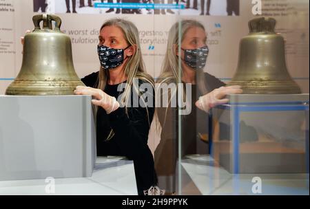 Victoria Ingles, conservateur principal au Musée national de la Marine royale, regarde la cloche du navire du HMS Repulse qui a été coulé avec le HMS Prince de Galles après une attaque aérienne japonaise le 10 1941 décembre.842 hommes ont perdu la vie dans ce qui est l'une des pires catastrophes de l'histoire navale britannique.Date de la photo: Mercredi 8 décembre 2021. Banque D'Images