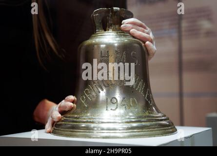 Victoria Ingles, conservateur principal au Musée national de la Marine royale, ajuste la cloche du navire du HMS Prince de Galles qui a été coulé avec le HMS Repulse après une attaque aérienne japonaise le 10 1941 décembre.842 hommes ont perdu la vie dans ce qui est l'une des pires catastrophes de l'histoire navale britannique.Date de la photo: Mercredi 8 décembre 2021. Banque D'Images