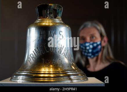 Victoria Ingles, conservateur principal au Musée national de la Marine royale, regarde la cloche du navire du HMS Prince de Galles qui a été coulé avec le HMS Repulse après une attaque aérienne japonaise le 10 1941 décembre.842 hommes ont perdu la vie dans ce qui est l'une des pires catastrophes de l'histoire navale britannique.Date de la photo: Mercredi 8 décembre 2021. Banque D'Images