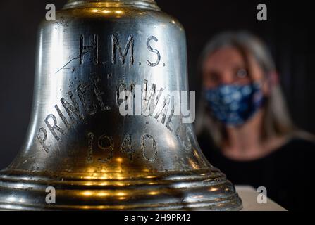 Victoria Ingles, conservateur principal au Musée national de la Marine royale, regarde la cloche du navire du HMS Prince de Galles qui a été coulé avec le HMS Repulse après une attaque aérienne japonaise le 10 1941 décembre.842 hommes ont perdu la vie dans ce qui est l'une des pires catastrophes de l'histoire navale britannique.Date de la photo: Mercredi 8 décembre 2021. Banque D'Images