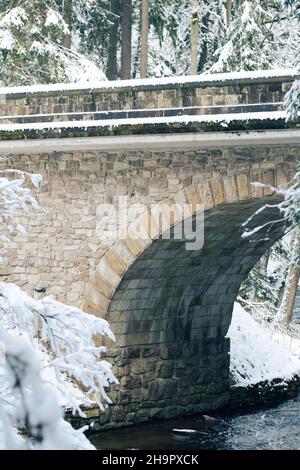 Plan vertical de l'ancien pont en pierre au-dessus de la rivière Divoka Orlice en hiver.Europe. Banque D'Images