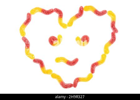 Symbole de visage en forme de coeur anthropomorphique fabriqué à partir de vers gommeux isolés sur fond blanc Banque D'Images