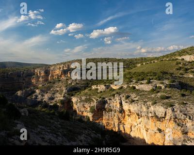 Vue sur les murs de roche rouge de 'Barranco de la Hoz Seca' à Jaraba (Saragosse) pendant une journée nuageux d'été. Banque D'Images