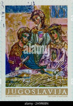 Photo d'un timbre-poste de 10 dinars de Yougoslavie avec trois figures peintes Banque D'Images